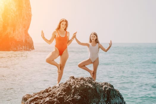 Silhouette mother and daughter doing yoga at beach. Woman on yoga mat in beach meditation, mental health training or mind wellness by ocean, sea