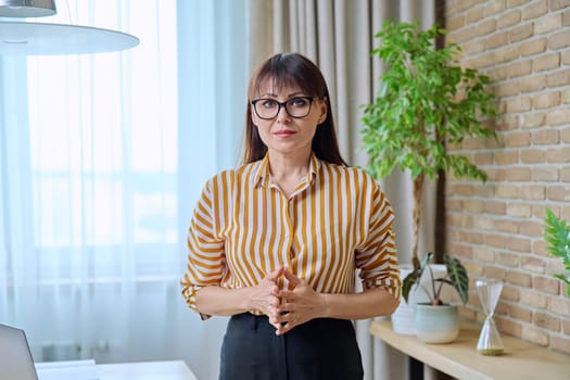 Portrait of business elegant middle-aged woman in office. Confident sserious uccessful female looking at camera. Job service leadership career, control management administration, mature people concept