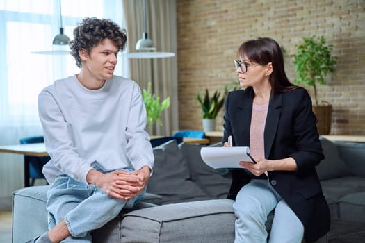 Young guy in therapy session discussing his emotional problems with female psychotherapist. Psychological assistance services, mental health, counseling, support, psychotherapy, psychology concept