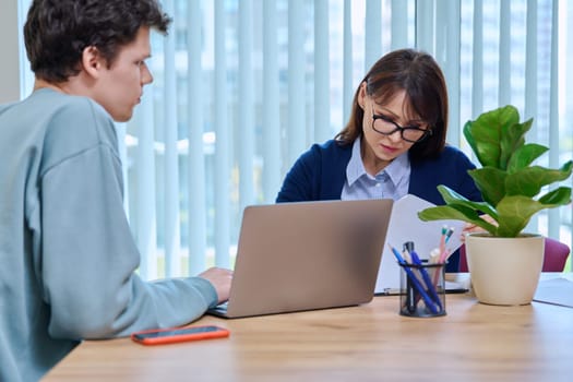 Guy student 18, 19 years old at therapy meeting with psychologist, social worker, mentor in college office. Social life, mental health, psychology, youth concept