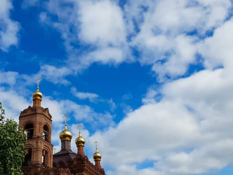 Domes of the church on the background of a blue sky with clouds. High quality photo