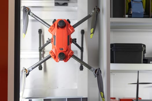 A modern drone suspended above a workstation, ready for operation.