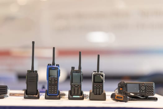 Array of communication devices, including radios and phones, on display.