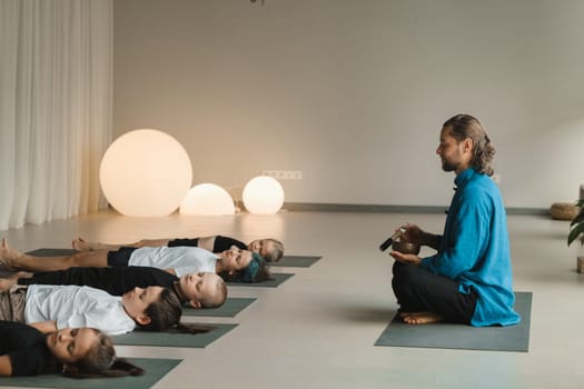 Children relax lying down to the sounds of a Tibetan bowl in the fitness room. Children's yoga.