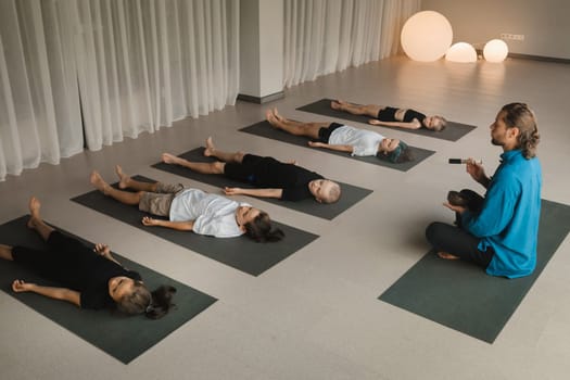 Children relax lying down to the sounds of a Tibetan bowl in the fitness room. Children's yoga.