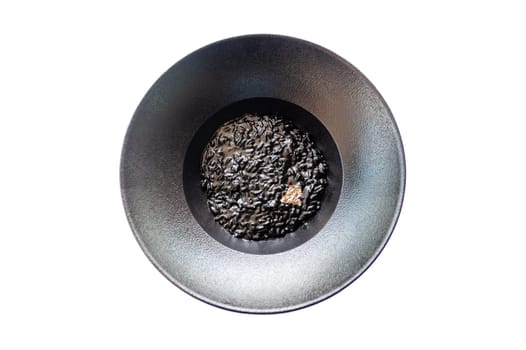 Black risotto on a black plate isolated. High quality photo