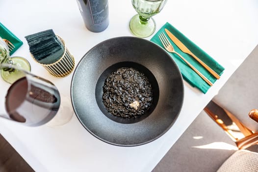 Black risotto on a black plate isolated. High quality photo