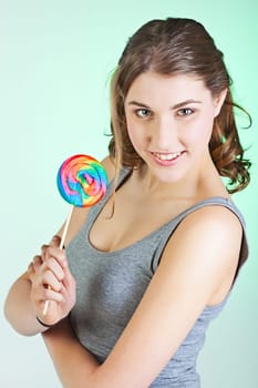 Portrait of smiling teenager girl holding colorful lollipop
