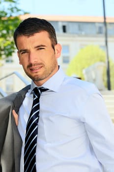 An attractive business man is walking outdoor