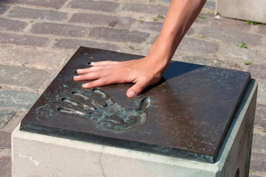 Young boy hand in a metal handprint