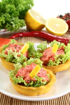 Corn tartlets with pollock salad against a white background