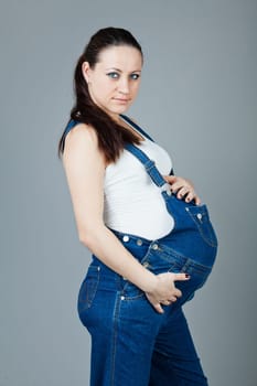beautiful young pregnant woman with a gray background