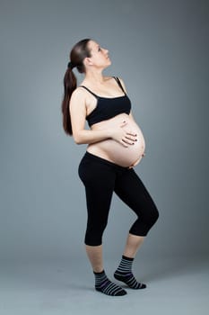 beautiful young pregnant woman with a gray background