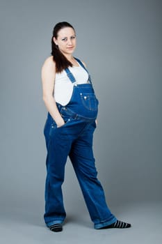beautiful young pregnant woman with a gray background