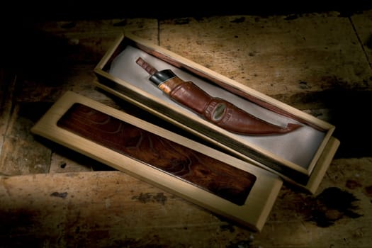 Handmade knife with a bone and wood handle and leather sheath.