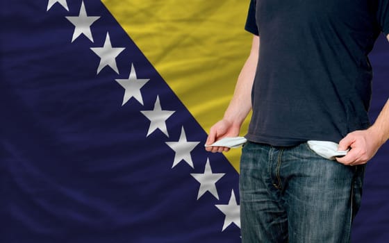 poor man showing empty pockets in front of bosnia herzegovina flag