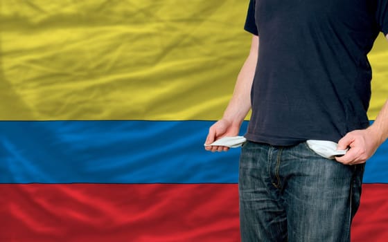 poor man showing empty pockets in front of columbia flag