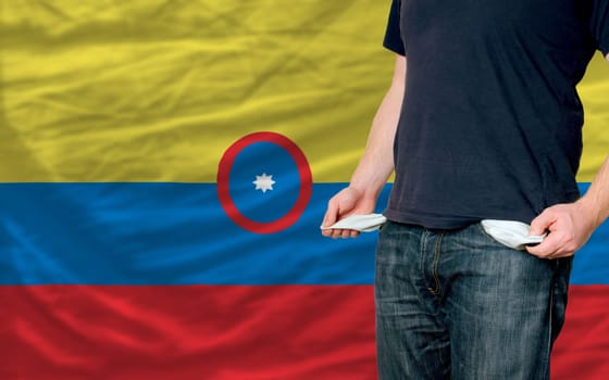 poor man showing empty pockets in front of columbia flag