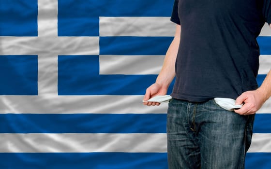 poor man showing empty pockets in front of greece flag