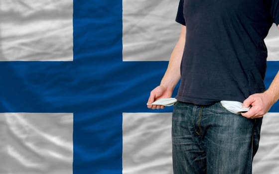poor man showing empty pockets in front of finland flag