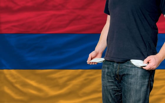 poor man showing empty pockets in front of armenia flag