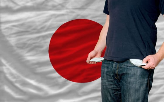 poor man showing empty pockets in front of japan flag