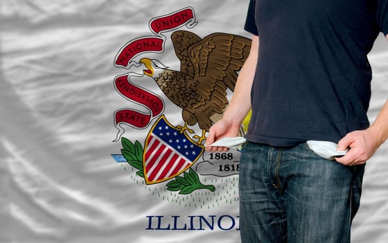 poor man showing empty pockets in front of american state of illinois flag