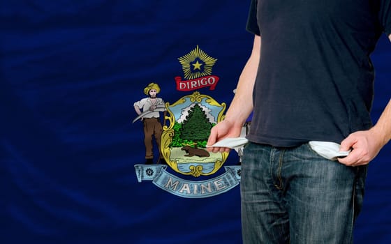 poor man showing empty pockets in front of american state of maine flag