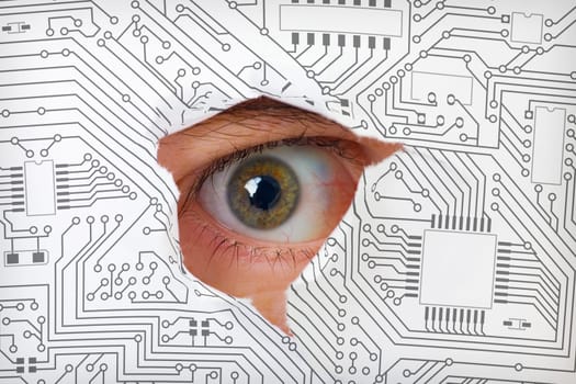 Human eye looking through a hole in the electronic circuit