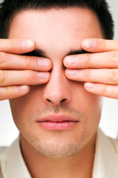 young business man covering his eyes close up shoot