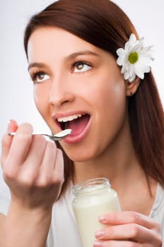 young beautiful woman eating yogurt close up
