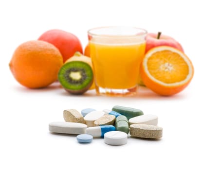 Pills with fresh fruit in background isolated