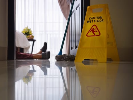 housemaid had accident at work while cleaning floor in hotel room. Side view, low angle