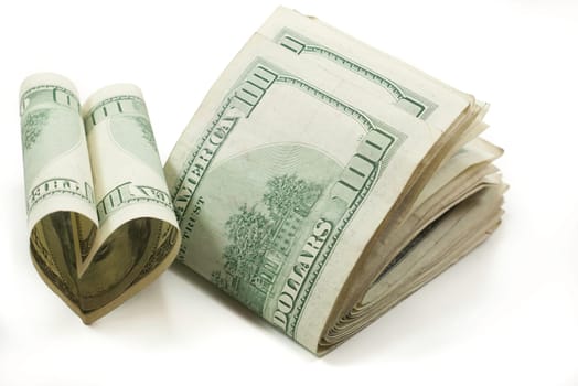 love of money stack of folded 100 dollar bills one shaped like a heart