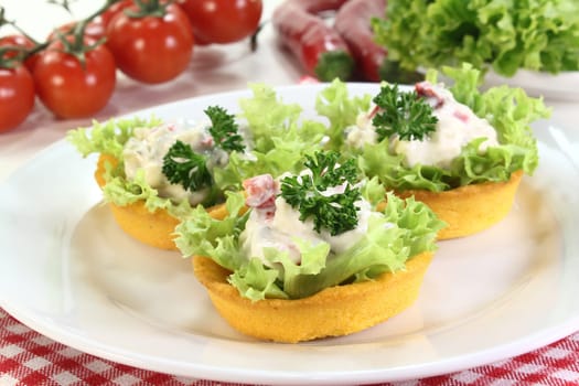 Corn tartlets with cheese salad against white background