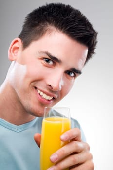 young man drinking orange juice close up