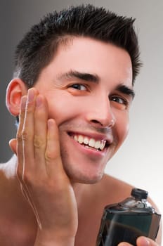 Young man applying after shave close up