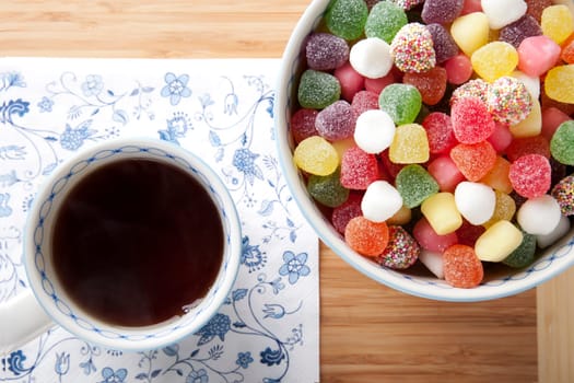 Cup of tea and bowl of jelly candies.