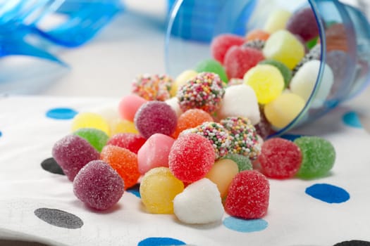 Sugar coated jelly candies spilling from a cup