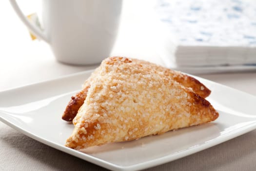 Pastries covered in sugar on white plate.
