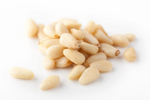 A small group of pine nuts on plain background.