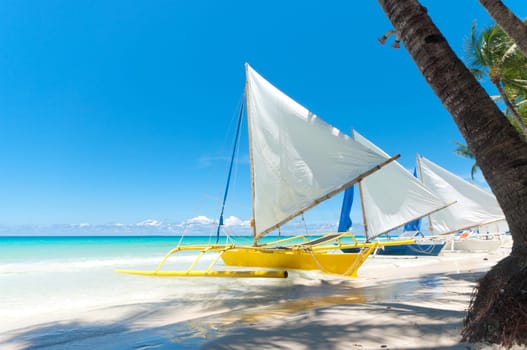 traditional paraw sailing boats on white beach on boracay island, Philippines