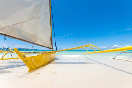 traditional paraw sailing boats on white beach on boracay island, Philippines