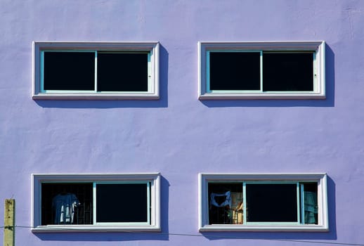 Artistic background. Windows on the purple wall with clear and right colors.