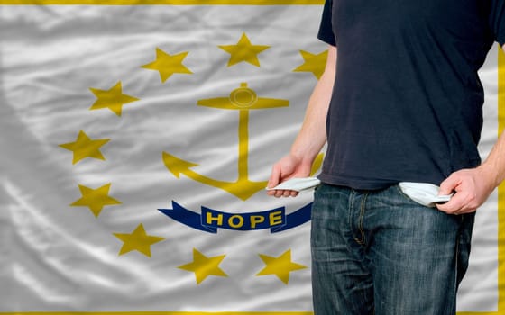 poor man showing empty pockets in front of american state of rhode island flag