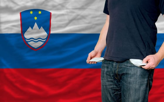 poor man showing empty pockets in front of slovenia flag