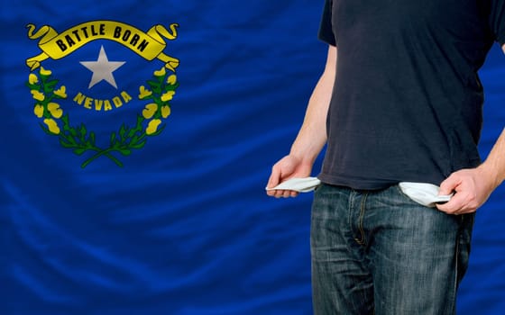 poor man showing empty pockets in front of american state of nevada flag