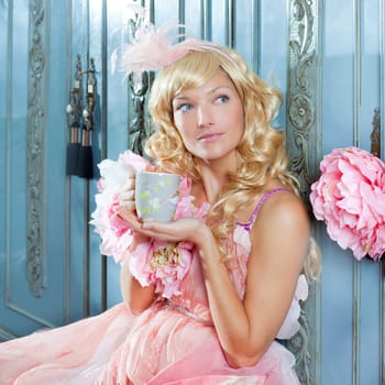 blond fashion princess woman drinking tea or coffee at home with vintage pink dress