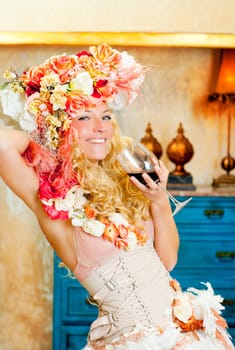 baroque fashion blond womand drinking red wine in grunge house