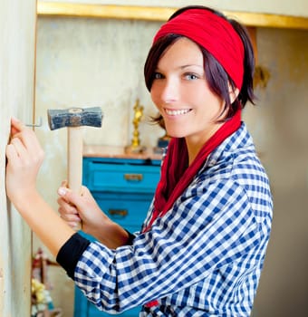 Diy fashion woman with nail and hammer on grunge house